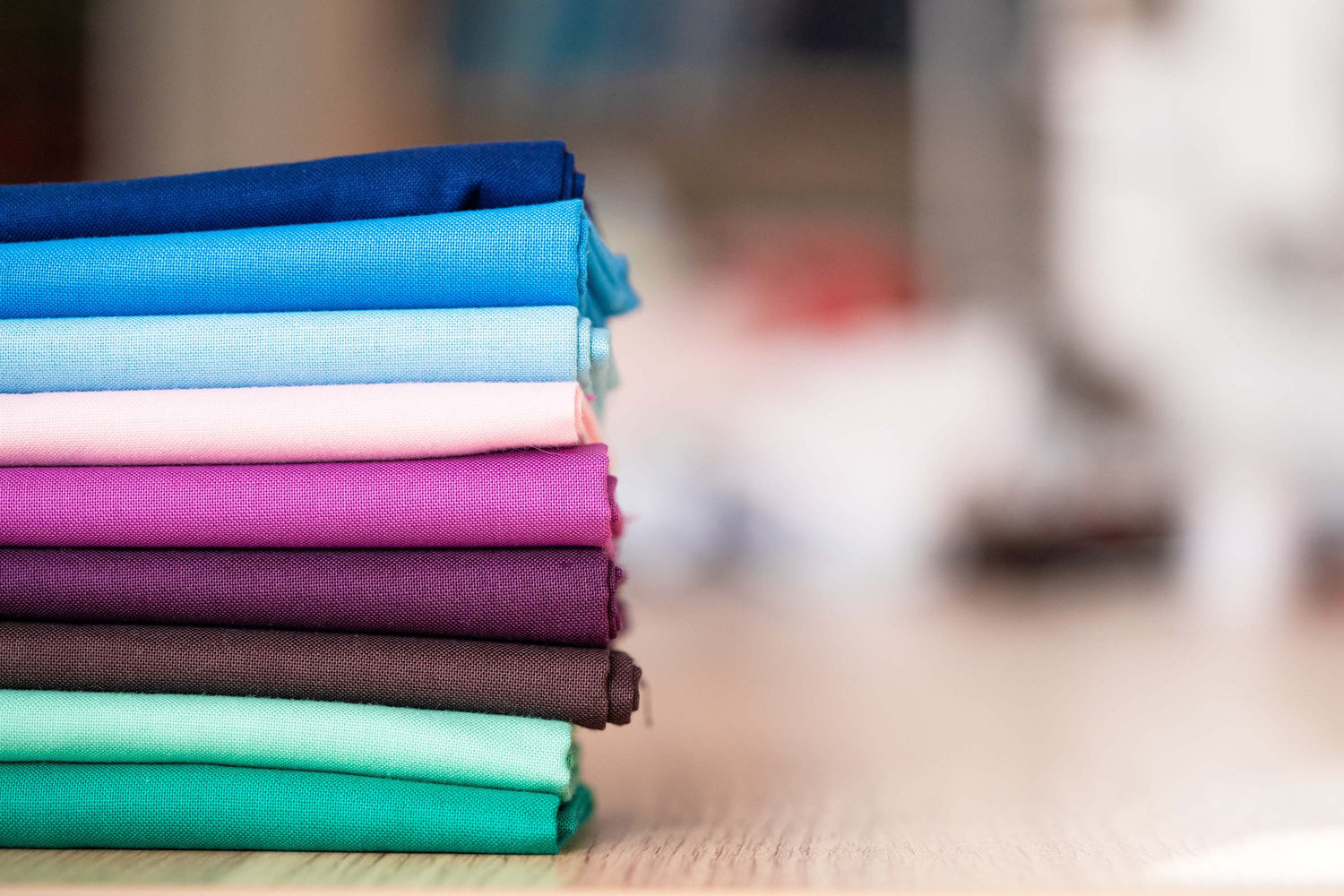 a pile of precut fabrics in a colour order